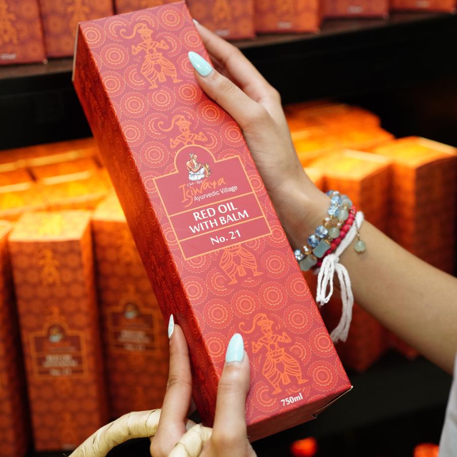 Warm medicinal oils infused with wild herbs pouring from a traditional copper vessel into an artisanal carved bowl